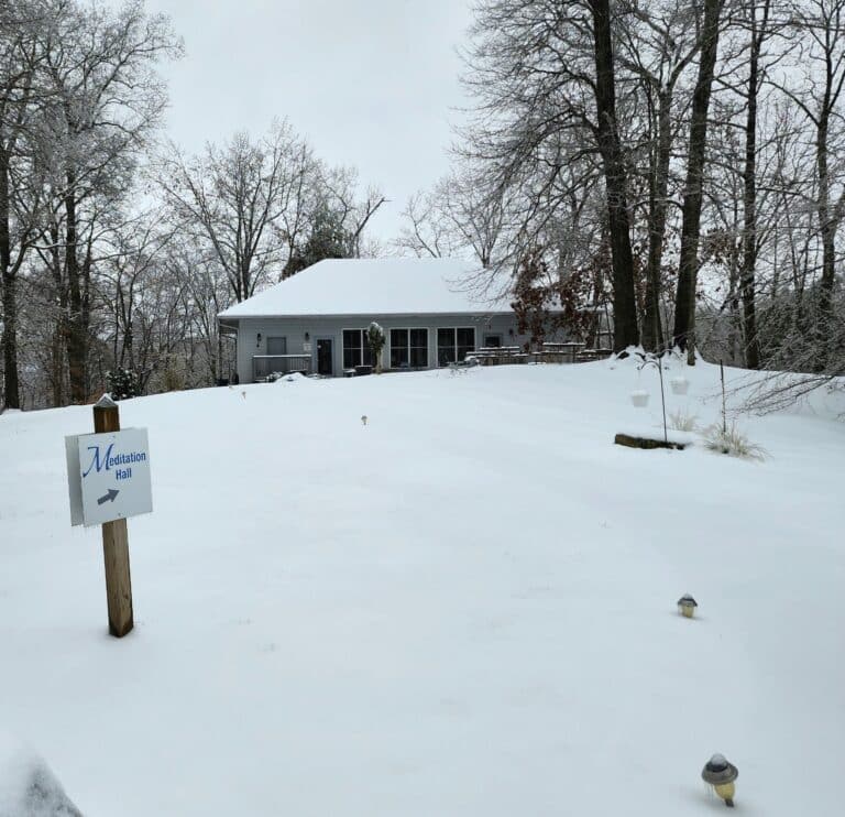 photograph of a meditation hall on a hill, covered in snow